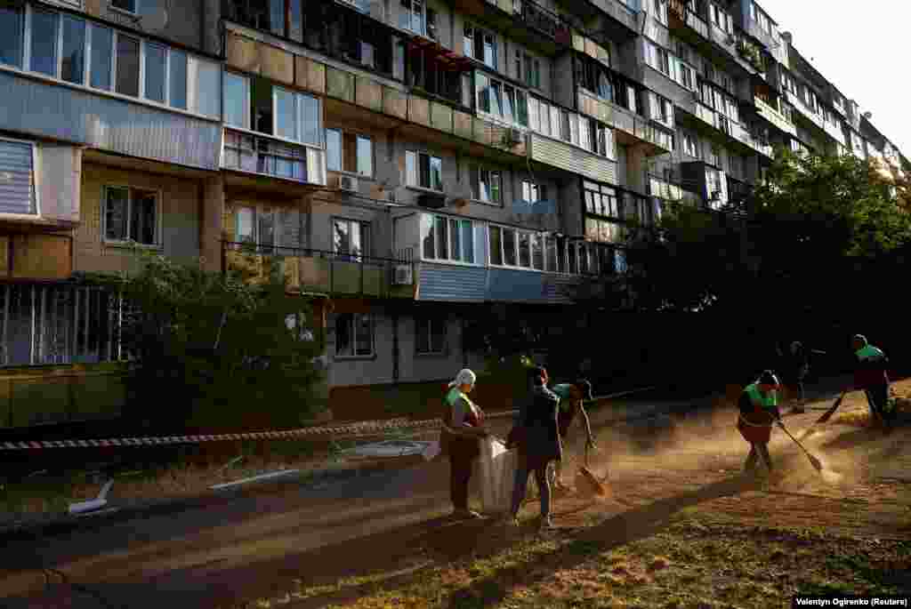 Municipal workers clear away the debris at the site of the residential building damaged during the early morning attack. Russia has intensified missile and drone attacks on the Ukrainian capital as Kyiv prepares to launch a counteroffensive. Russia says Ukrainian shelling of border areas has increased in recent weeks as Kyiv prepares its counterattack