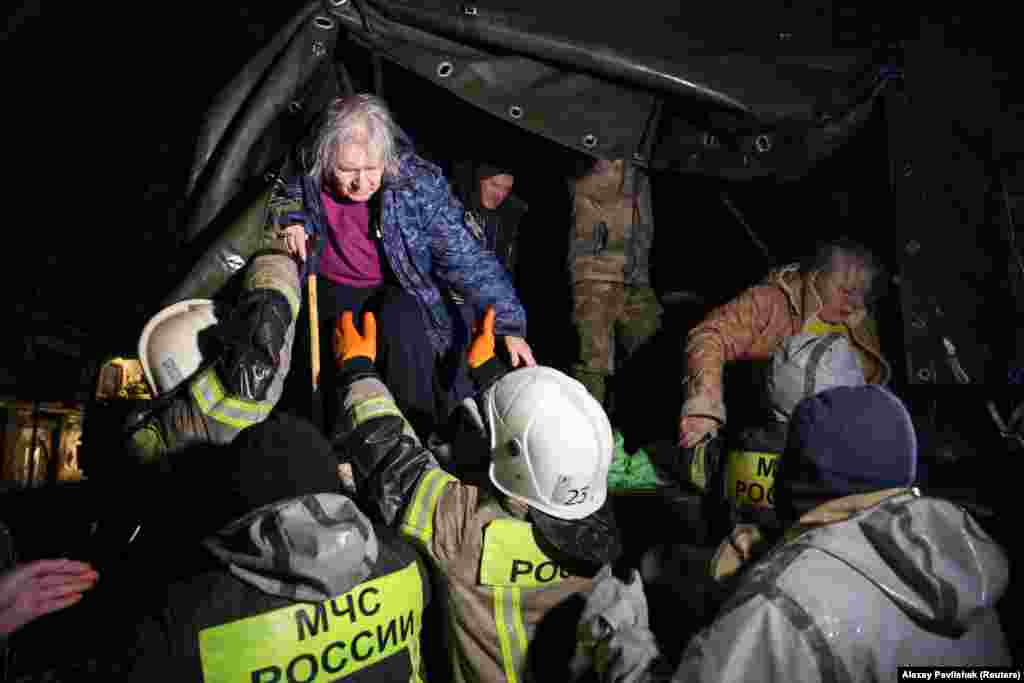 Local residents are helped out of a truck by rescuers during an emergency evacuation from a flooded street in the Crimean city of Yevpatoria on November 26. A Russian-installed official in the region that Moscow annexed from Ukraine in 2014, Oleg Kryuchkov, said one person had been killed. 