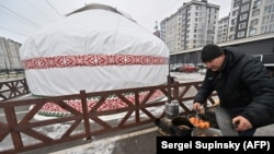 A volunteer cooks Kazakh bread outside an initiative dubbed the "Yurt of Invincibility" organized by representatives of the Kazakh diaspora in Ukraine in the town of Bucha.