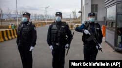 Police officers stand at the outer entrance of the Urumqi No. 3 Detention Center in Dabancheng in western China's Xinjiang Province in 2021.