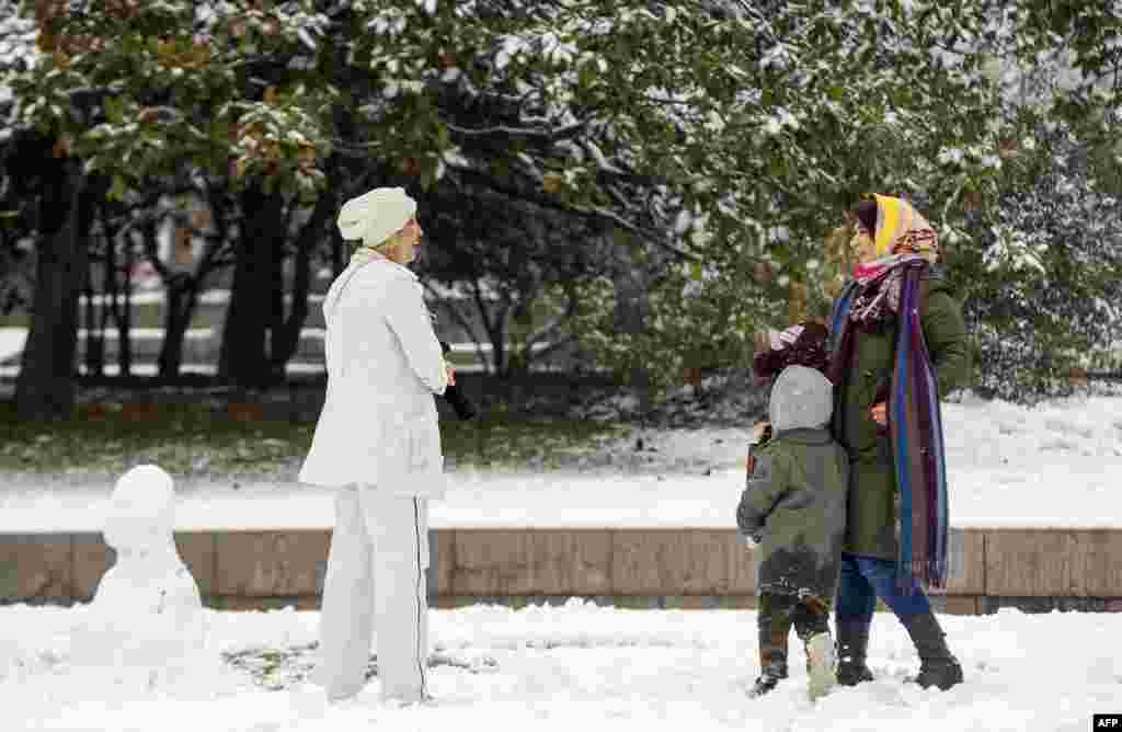 Women chatting in a park after a snowfall in Tehran on December 24. A Voice of America report cites a Washington-based rights group as claiming patrols by the morality police disappeared from Tehran's wealthier neighborhoods in recent weeks. 