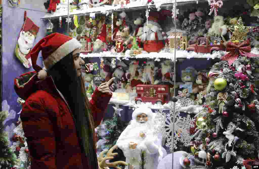 A woman looking at Christmas decorations in Tehran on December 25. As of December 26, protests were ongoing in some parts of Iran over the deadly crackdowns on demonstrations sparked by Amini's death in September. 