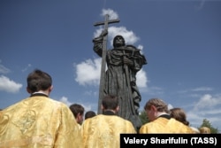 Members of the clergy mark the 1031st anniversary of the Christianization of Rus by a monument to St. Vladimir in Borovitskaya Square in Moscow in 2019.