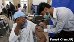 A man receives the Sinopharm coronavirus vaccine from a healthcare worker at a vaccination center in Karachi on March 10.