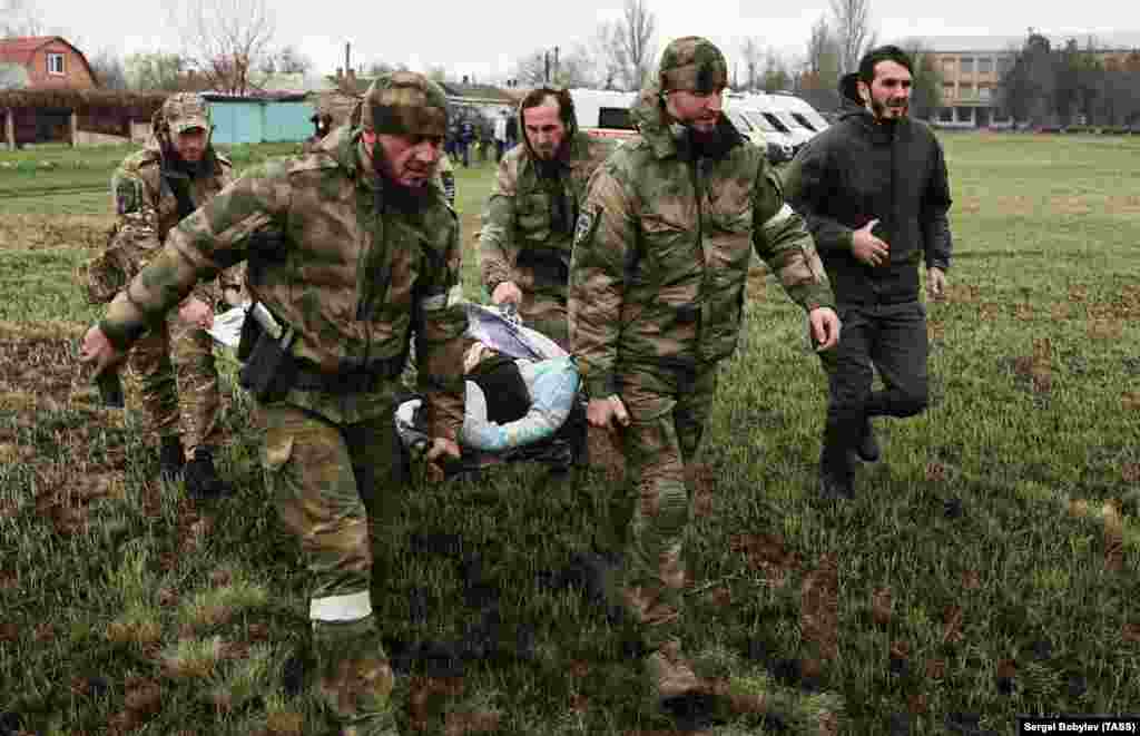 Troops from Russia's Chechnya region evacuate a wounded man from the battlefield in Novoazovsk on April 12. 