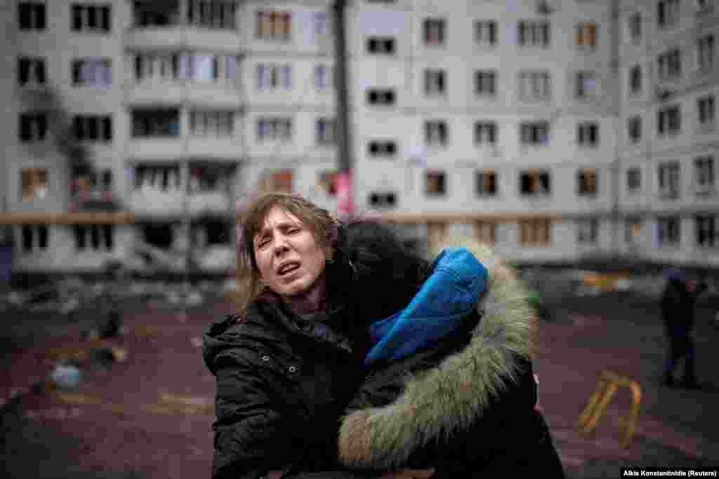 Two women react in the yard of an apartment complex in Kharkiv that was hit by artillery on April 13. 