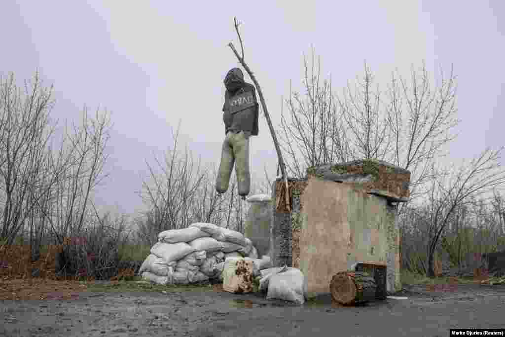 A dummy dressed as a Russian fighter hangs outside the village of Barvinkove on April 12. An obscene insult is written on the signboard. 