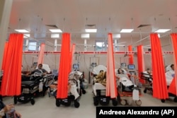 Patients lie on beds in an emergency room that has been turned into a COVID-19 unit due to the high number of cases, at the Bagdasar-Arseni hospital in Bucharest.