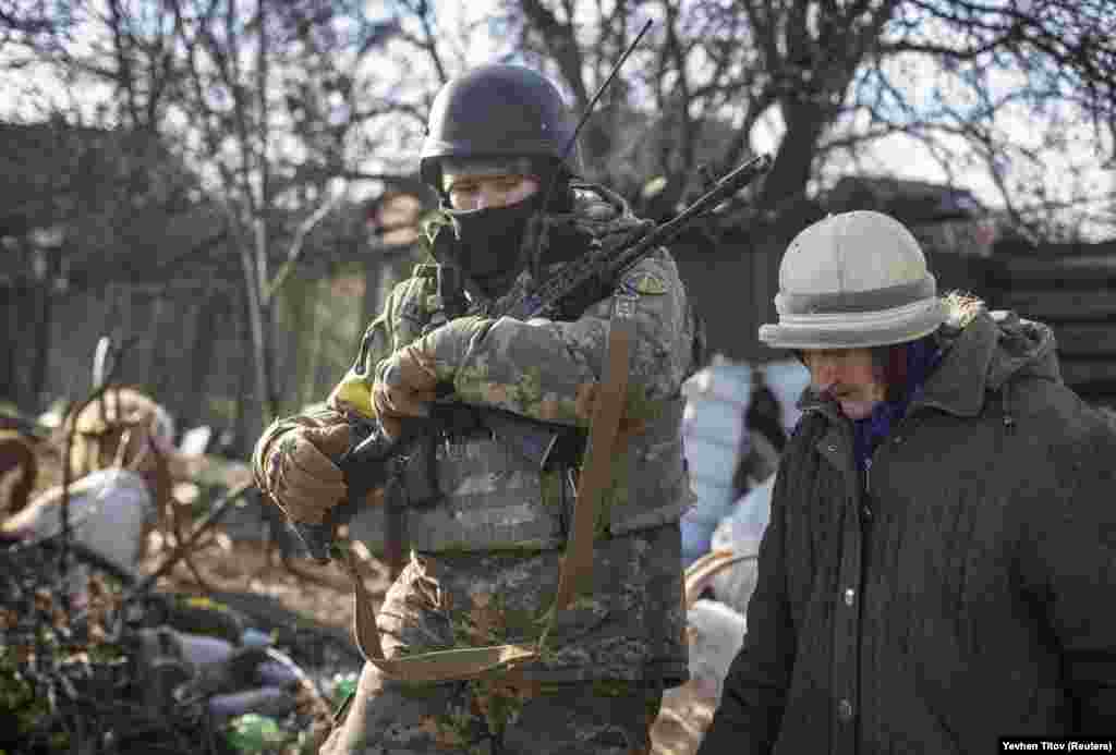 A Ukrainian soldier escorts a local resident on December 7. Not only the shelling, but the winter months without electricity and water pose serious challenges to Bakhmut's residents.