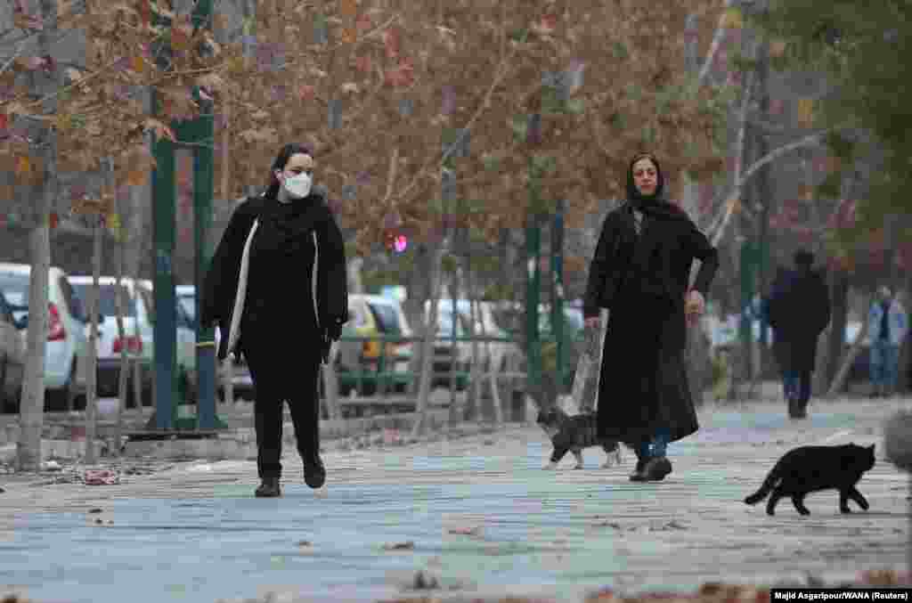 Two women, one of whom has removed her head scarf, walk in Tehran on December 6. In 1983, Iran's Islamist government decreed that "women who appear in public without religious hijab will be sentenced to a whipping of up to 74 lashes," though short terms of imprisonment were a more common punishment. 