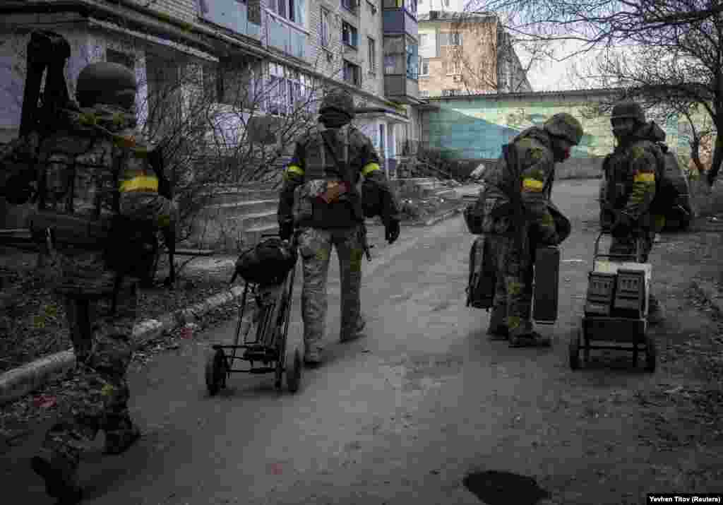 Ukrainian service members move weapons and ammunition through the empty streets of Bakhmut on December 7. Western allies have provided the Ukrainian military with cold-weather gear in addition to weapons and ammunition to help them survive the winter. 