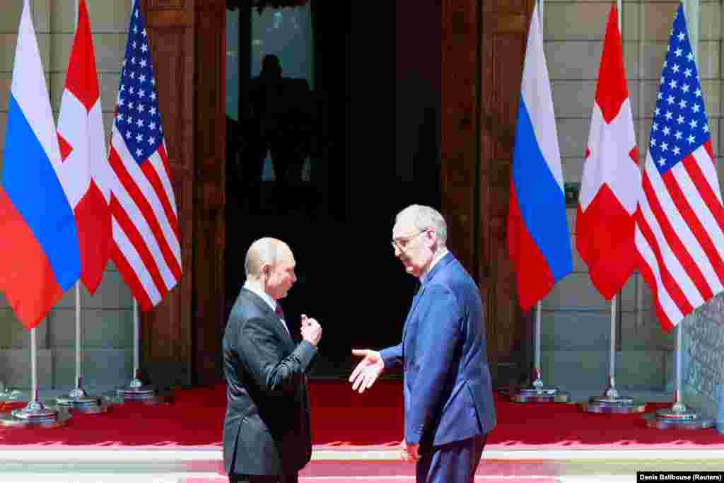 Swiss President Guy Parmelin greets Russia's President Vladimir Putin before he enters the villa. 