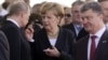 The visit of German Chancellor Angela Merkel (center) to Kyiv this weekend has raised hopes that she may be able to help Russian President Vladimir Putin (left) and Ukrainian President Petro Poroshenko strike a deal that would end the Ukraine crisis. (file photo)