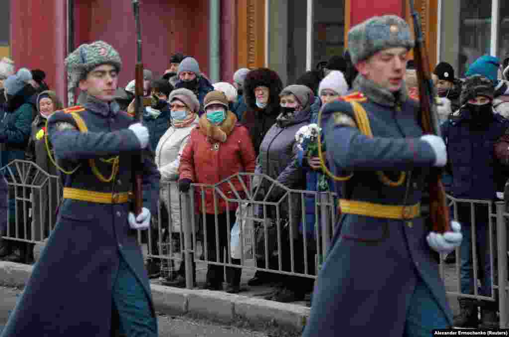 Local residents from a region controlled by a Russia-backed separatist group that calls itself the Donetsk People's Republic watch an honor guard on January 22 during the ceremony to mark the seventh anniversary of a Donetsk trolleybus being hit by shelling.