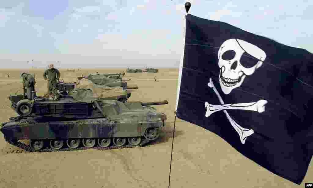 U.S. Marine Corps reservists fly their "Jolly Roger" on an M1A1 Abrams tank at U.S. Marine Corps Camp Grizzly in Kuwait on February 16, 2003. The Abrams has gone through various upgrades, resulting in the M1, M1A1, and M1A2 versions, with each having improvements in armament, protection, and electronics. 