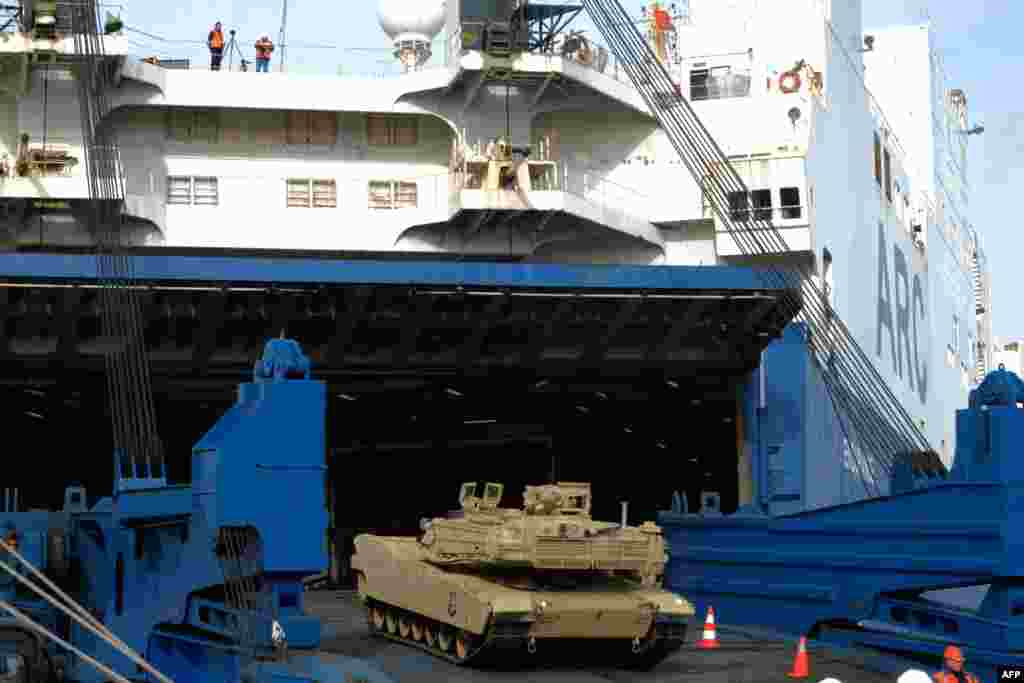 Military personnel unload M1 Abrams tanks at Bremerhaven, Germany, on February 21, 2020. Mark Hertling, a former commander of U.S. ground forces in Europe, estimated German-made Leopard 2 tanks could reach Ukraine's battlefields as soon as March while U.S. tanks, which need more logistical support, could be more than eight months away. 