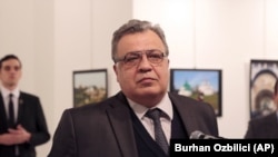 Андрей Карлов выступает на открытии выставки в Анкаре. Слева на заднем плане — Мевлют Алтынташ, 19 декабря 2016 года