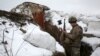 A Ukrainian soldier checks his weapon as he stands in a trench on the front line with Russia-backed separatists near the village of Zolote in the eastern Luhansk region on January 21. 