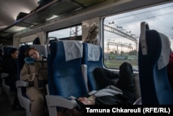 Passengers sleep as the sun rises and the train approaches Kyiv.