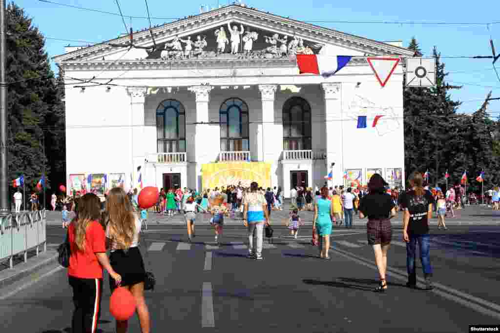 Mariupol locals walking in front of the Donetsk Regional Drama Theater during a French-themed festival in 2019. 