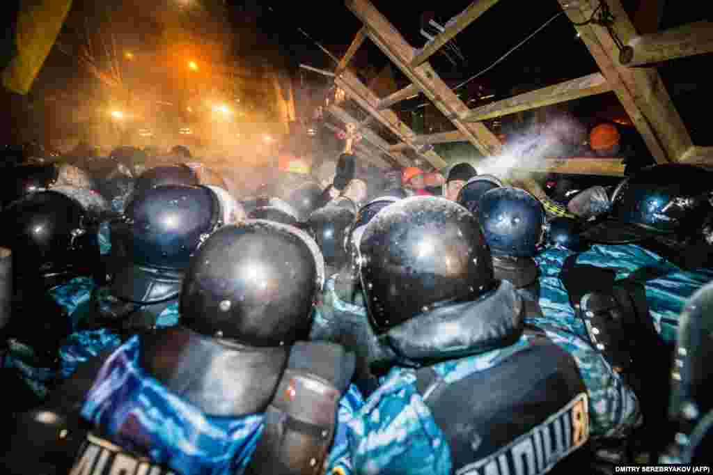 Riot police storm a barricade held by protesters on Independence Square in Kyiv late on December 11, 2013. The demonstrators defiantly refused to leave and resisted the police in a tense standoff. Berkut riot police and Interior Ministry special forces moved against the protesters at around 2 a.m. in a move that prompted U.S. Secretary of State John Kerry to express "disgust" over the crackdown.