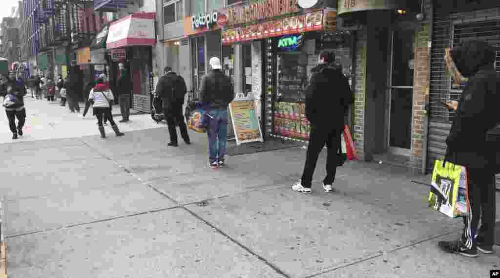 New Yorkers wear masks and maintain their distance in a long line outside Trader Joe's on March 25.