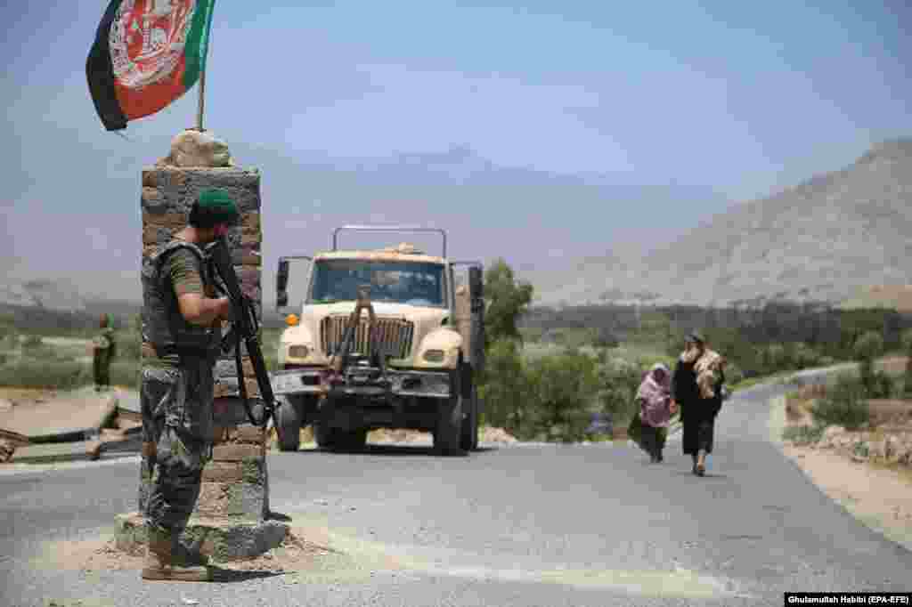 An Afghan soldier watches from a checkpoint in Laghman Province on July 8 after Afghanistan's security forces reportedly cleared the area of Taliban militants. 