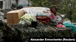A detail from a Reuters photo showing Russian soldiers atop an armored vehicle in the Ukrainian town of Popasna with household items that Alina Korenyuk says were stolen from her home. 