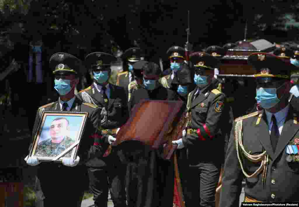 Armenian troops carry a photograph of Hambardzumian.
