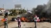 Djeca drže balone dok stoje kraj zapaljenih guma tokom prosvjeda protiv sporazuma o zajedničkim ruskim i turskim ophodnjama, na autocesti M4 u pokrajini Idlib, Sirija, 15. mart 2020.
