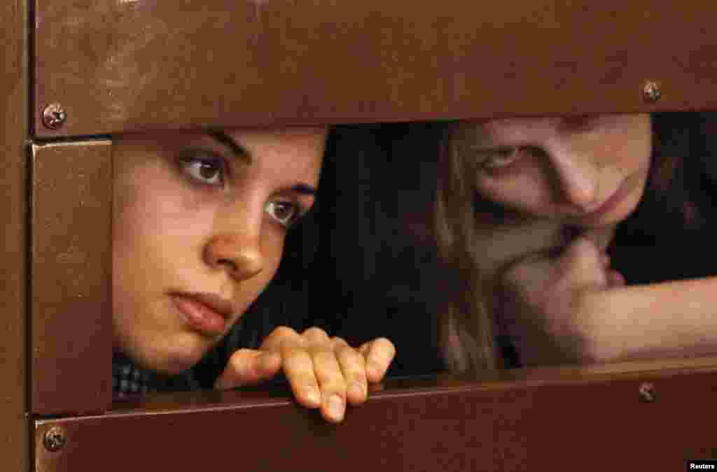 Nadezhda Tolokonnikova (left) and Maria Alyokhina look out from the defendant's cell in a Moscow courtroom on July 30.