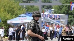 A Slovenian KFOR soldier stands on a road in front of barricades in the village of Rudare, in northern Kosovo, on August 5.