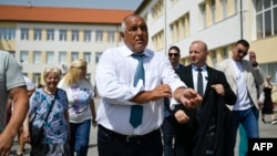 Former Bulgarian Prime Minister Boyko Borisov leaves a polling station after casting his ballot during the snap parliamentary and European Parliament elections at a polling station in Sofia on June 9.