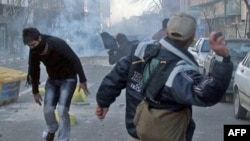 Protesters throw stones at riot police during an antigovernment demonstration in Tehran on February 14. 