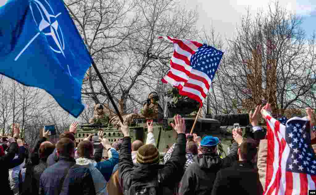 Supporters wave NATO and U.S. flags.
