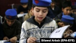 په پېښور کې د ښوونځي یو ماشوم کتاب لولي - پخوانی انځور. 