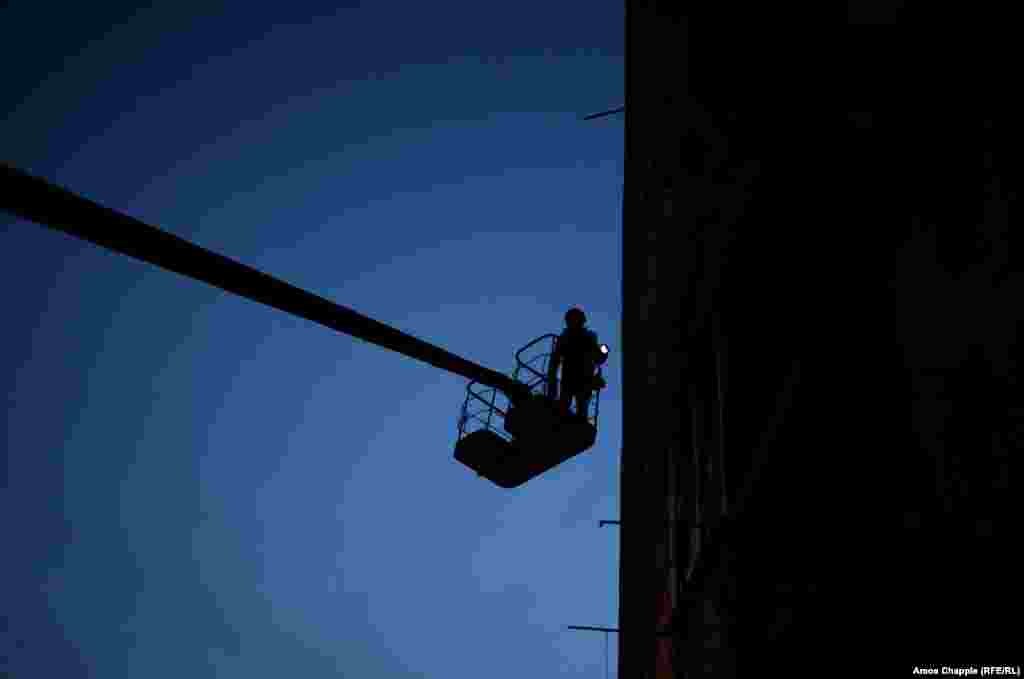Although told he is out of range of snipers, van Helten waits until after dark to paint the highest, most exposed parts of the mural.