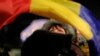 A woman waves a Romanian flag during a protest in Bucharest.