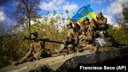 Українські військові на БТР їдуть дорогою між Ізюмом, що на Харківщині, і містом Лиманом Донецької області, 4 жовтня 2022 року