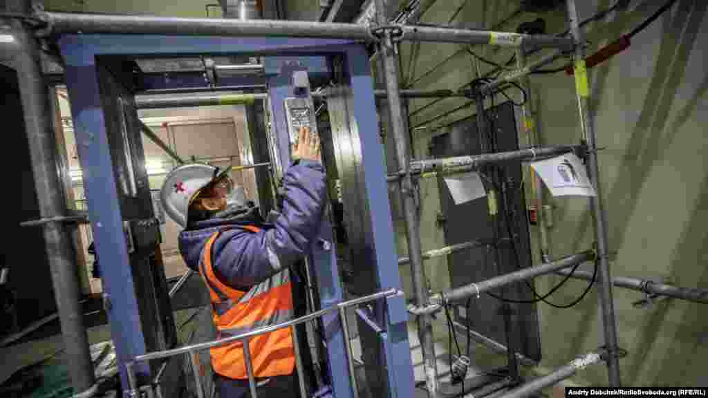 In order to move around Chernobyl&#39;s containment structure, workers must routinely check if they have been exposed to radiation. This worker tests radiation levels with monitoring equipment known as a dosimetric control system.