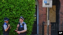 Polis məmurları Britaniya baş naziri Kir Starmerin Londondakı evinin yanğından zərər çəkən girişinin yaxınlığında dayanıblar.