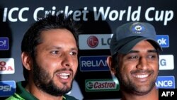 Pakistani cricket captain Shahid Afridi (left) with Indian captain Mahendra Singh Dhoni during a press conference at the Punjab Cricket Association Stadium in Mohali on March 29