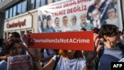 A journalist holds up a banner outside the headquarters of opposition newspaper Cumhuriyet in Istanbul during a protest in July.