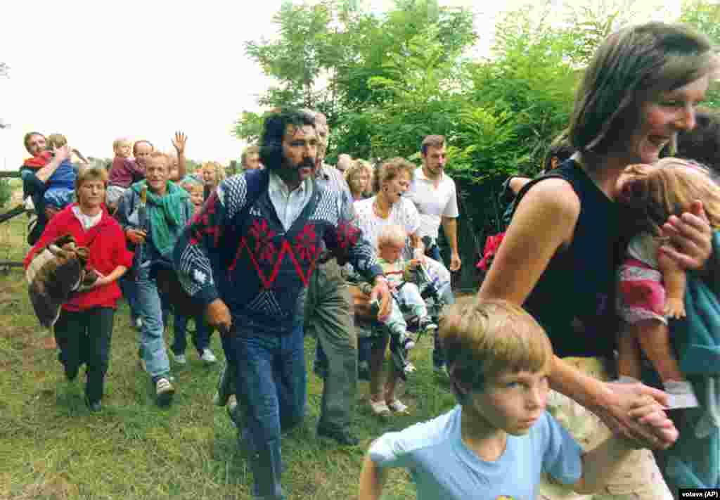 East Germans flee from Hungary into Austria on August 19, 1989, during the “Pan-European Picnic.” Thousands of East Germans began fleeing Hungary into Austria, including some 600 in a single day during a festival-like protest branded the Pan-European Picnic on the Austria-Hungary border. The exodus, which was soon openly permitted by Hungary, sparked furious protest from East Germany, which claimed its citizens had been "seduced and paid to emigrate...to slander our state." 