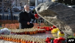 A man lays flowers at the Solovetsky Stone monument in central Moscow.