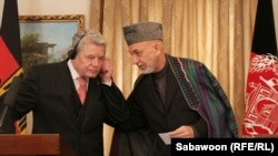 Afghan President Hamid Karzai (right) speaks with German President Joachim Gauck during a press conference at the Presidential Palace in Kabul on December 18.