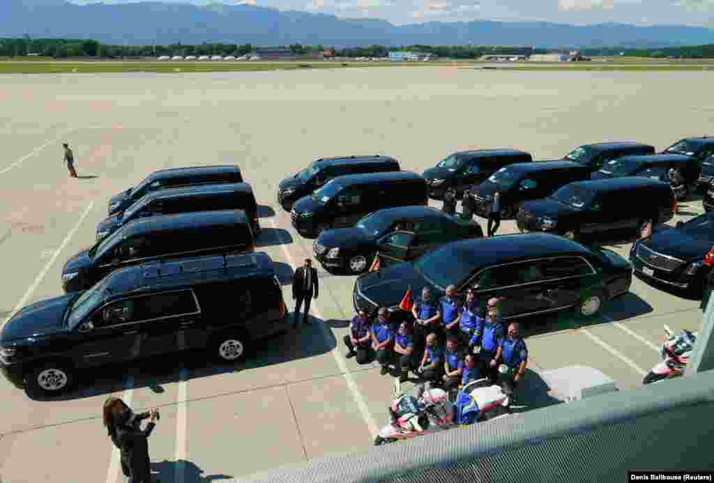 Geneva police pose for a photo next to a motorcade as they await the arrival of President Biden at Cointrin Airport on June 15. 