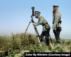 Tsar Nicholas II peering through periscope binoculars near a front line during World War I.