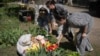 People lay flowers and toys at the site of Russia's deadly missile attack that hit residential housing on April 24, killing 12 civilians and injuring 87 in Kyiv, on April 25.