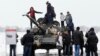 UKRAINE -- Local people pose on tank T-72 of the pro-Russian militant forces during celebration of Defender of the Fatherland Day at territory of former airport, in Luhansk, February 23, 2020